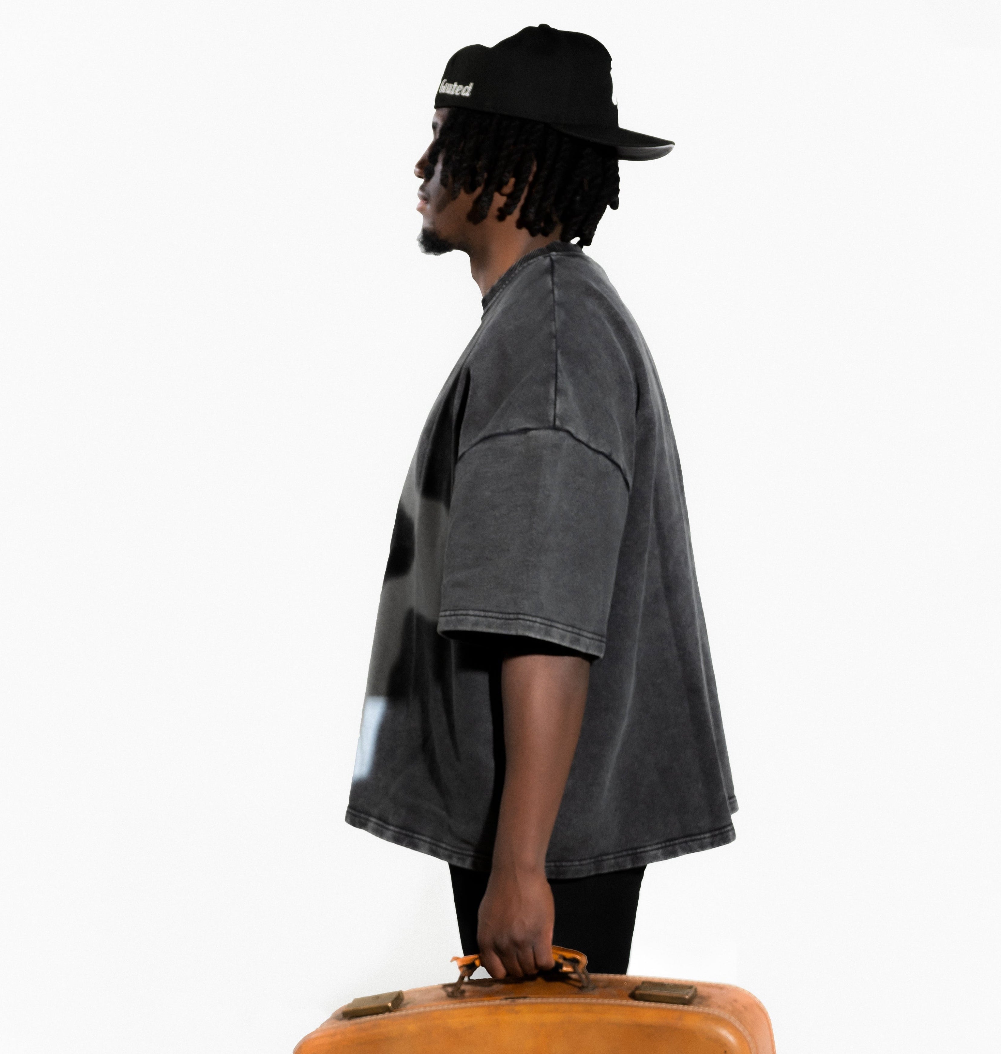 Person holding a brown suitcase on a white background